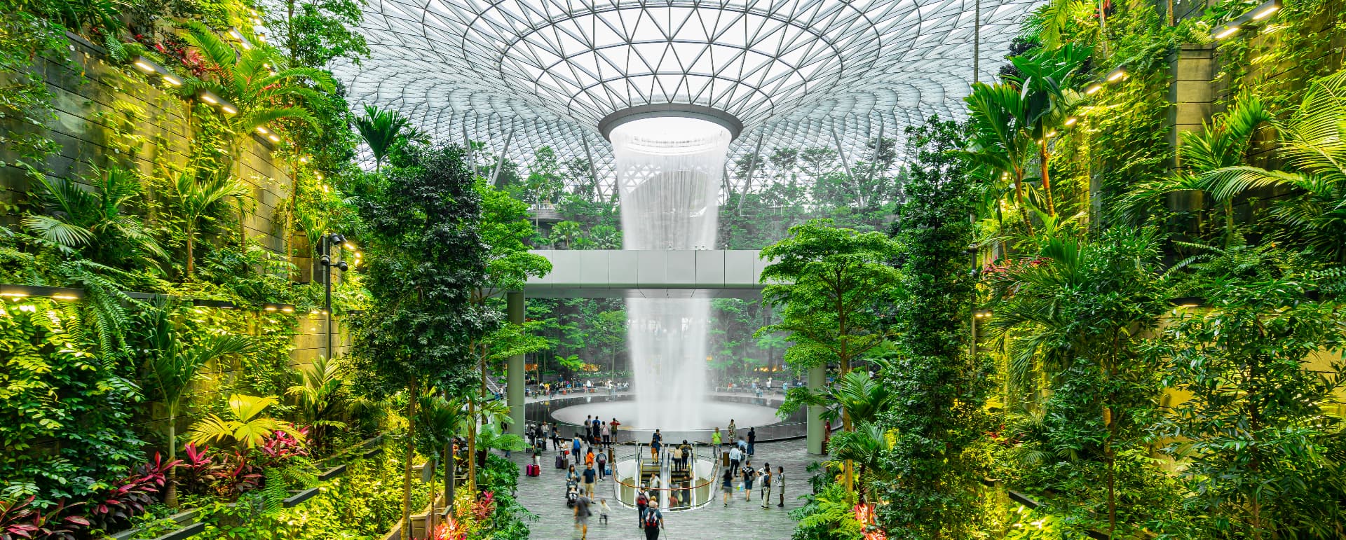 The Rain Vortex waterfall and terraced indoor forest beneath the glass canopy at Jewel Changi Airport